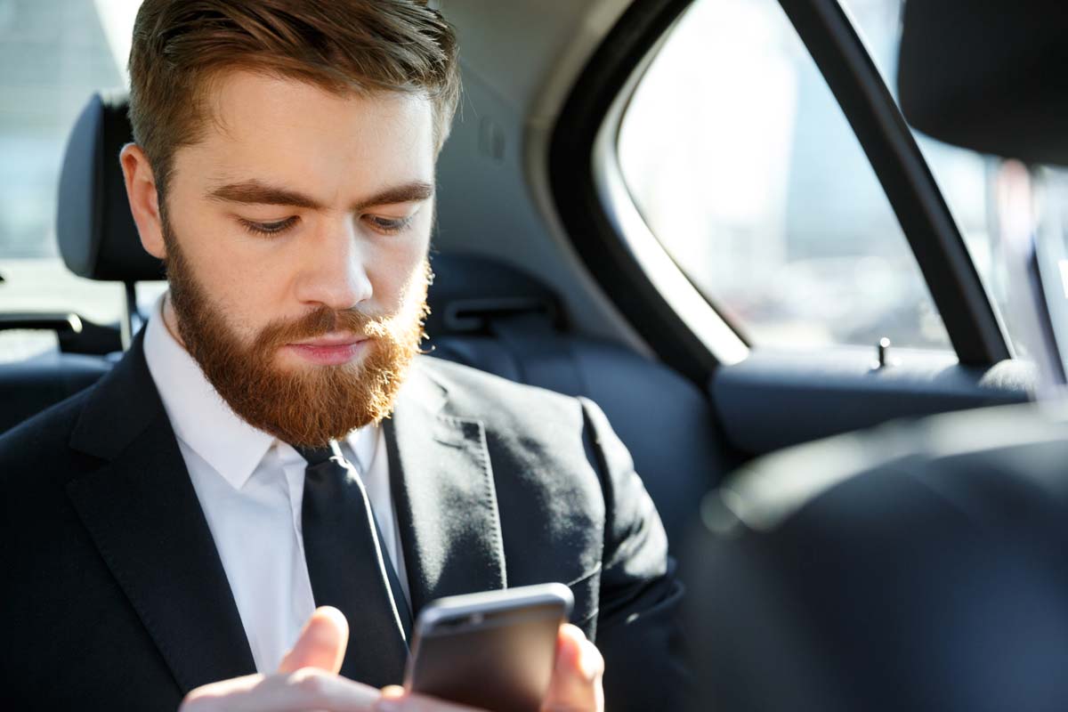 Bearded Business Man Using Cell Phone in Car