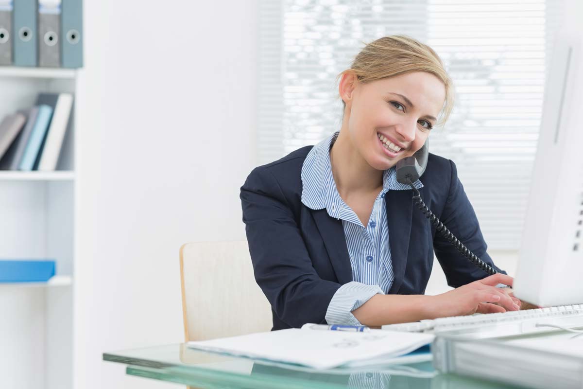 Smiling Business Woman Using Desk Phone