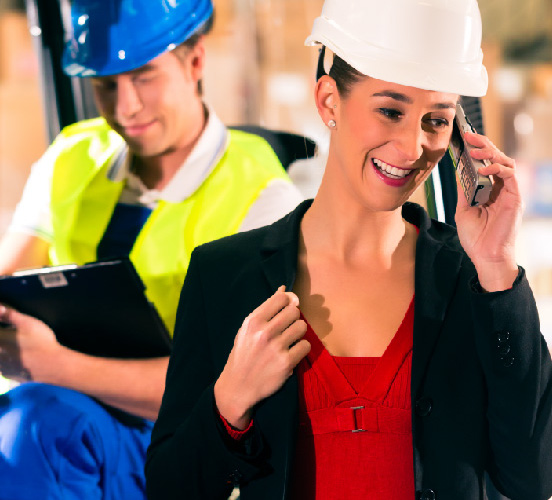Smiling Business Woman in Hard Hat on Phone