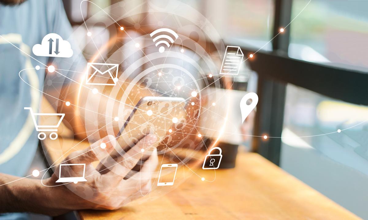 Man using mobile phone with communication icons floating around it