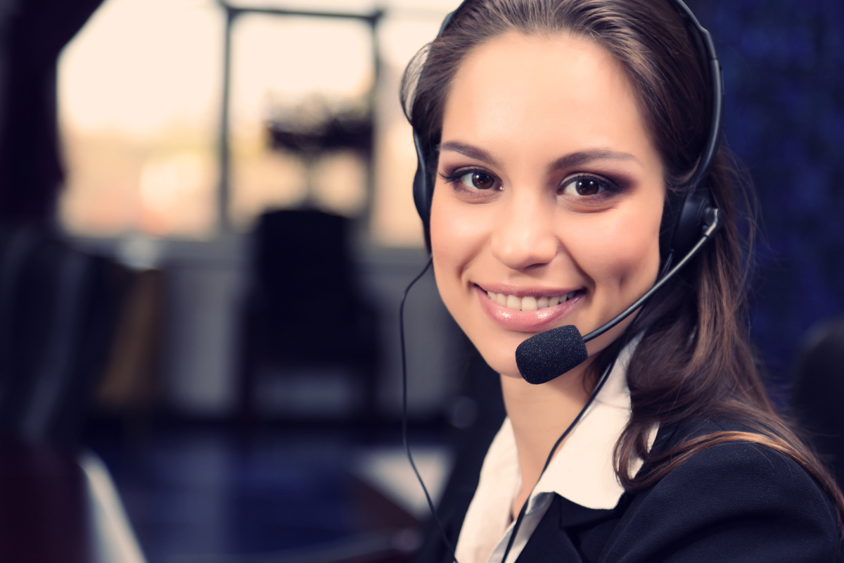 A contact center employee wearing a VoIP headset and smiling