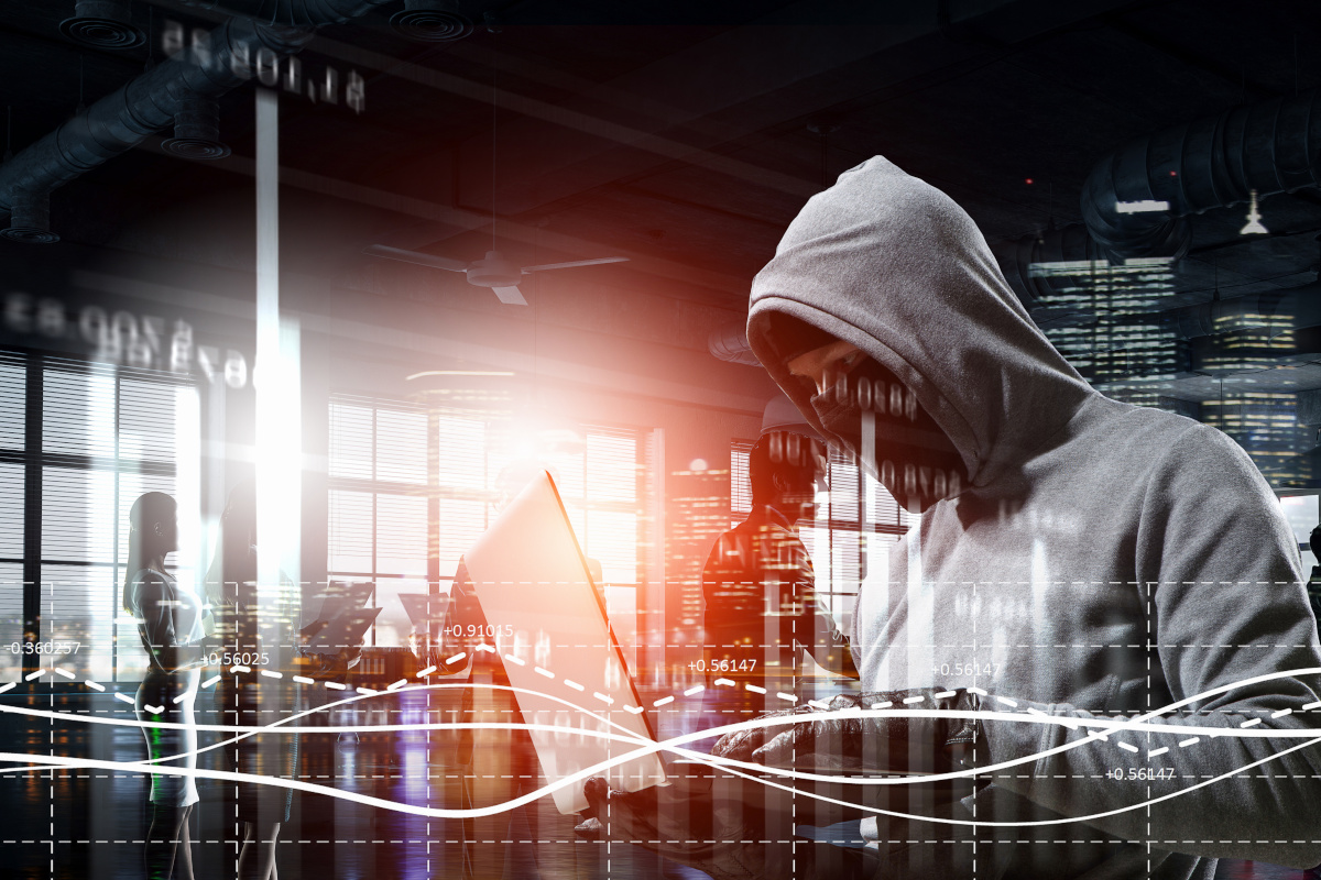 A person in a hoodie on a computer conveying the dangers of hacking