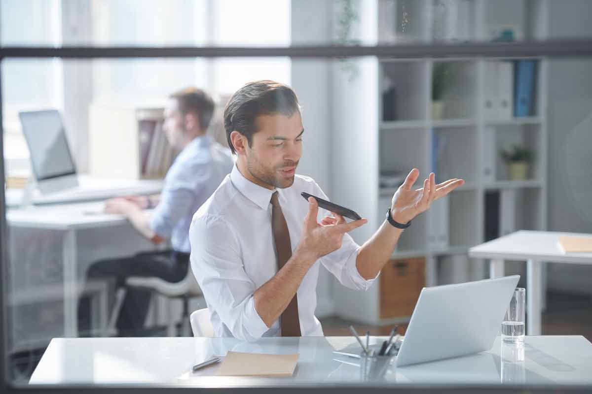 Businessman Recording Voice Message on a Smartphone