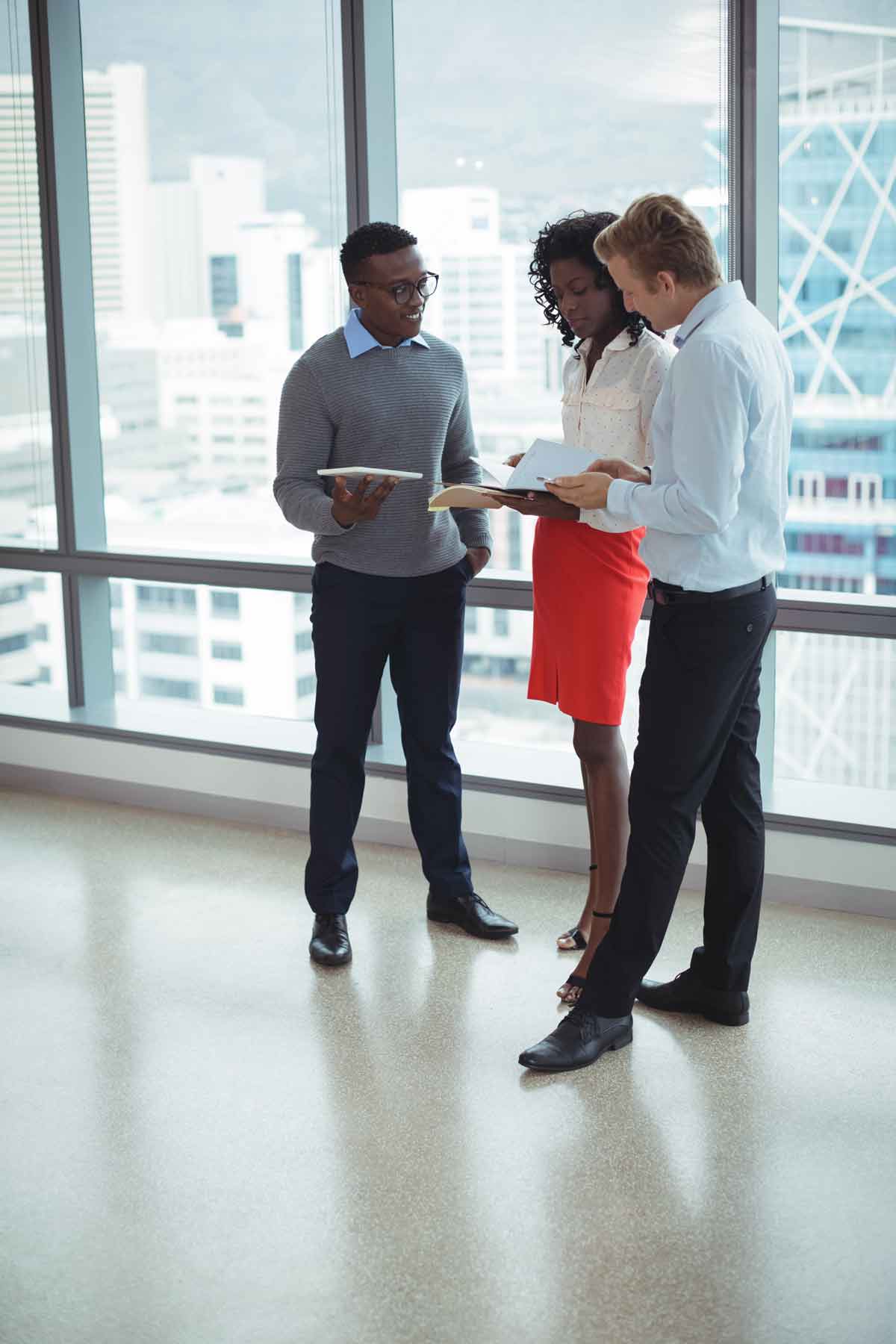 Young Business Team Having Discussion In Front of Window